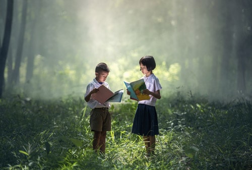 Boy and girl studying in forest